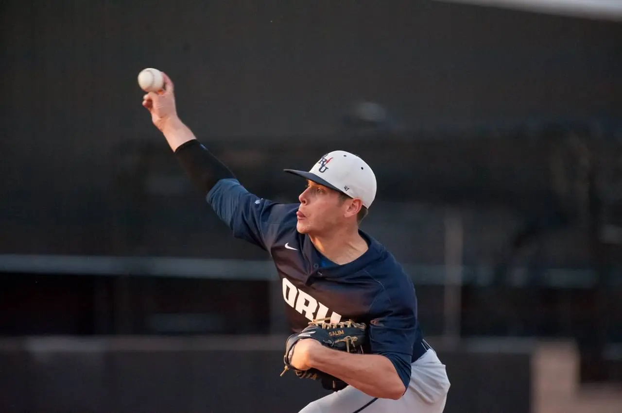 Coach Jacob Salim working with a baseball player